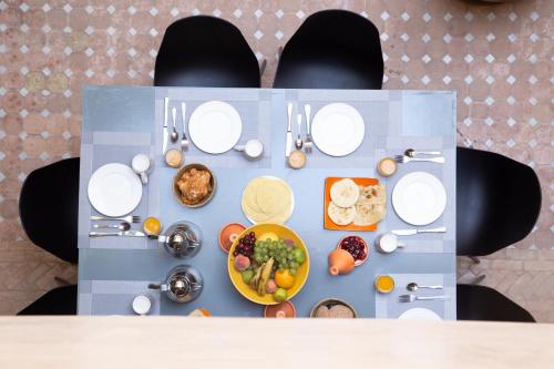 una mesa con platos blancos y comida en ella en RIAD KERDOUSS, en Marrakech