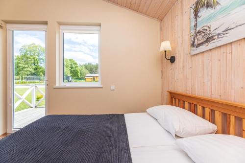 a bedroom with a bed and a window at Atostogų Medis in Šventoji