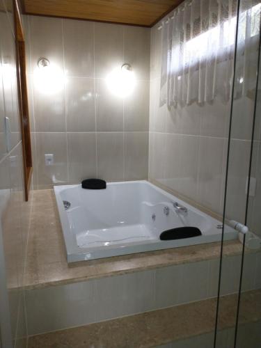 - Baño con bañera blanca y 2 luces en Chalés do Pardal en Visconde De Maua