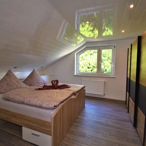 a bedroom with a bed with a large window at FeWo 4 - Erpolzheim in Erpolzheim
