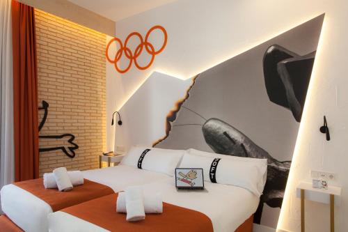 a hotel room with two beds and an olympics mural at Casual Socarrat Valencia - Adults Only in Valencia