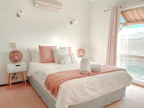 a white bedroom with a large bed and a window at Carnarvon 3BR & 2BA Holiday House in Carnarvon