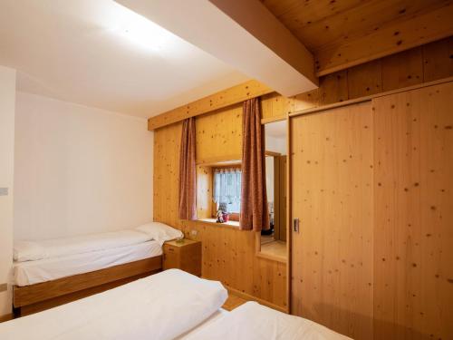 a bedroom with two beds and a window at Ciasa Lino Aloch in Pozza di Fassa