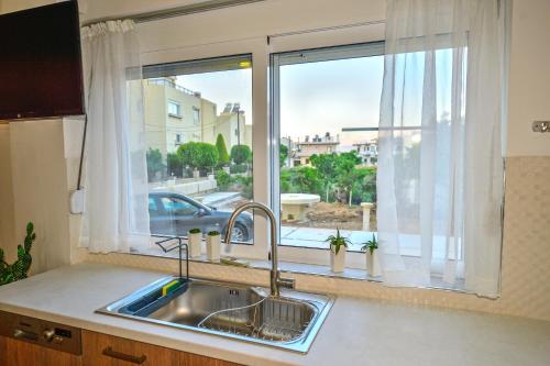 a kitchen sink and a window with a view of a street at Mpoulakis Apt 46 in Kissamos
