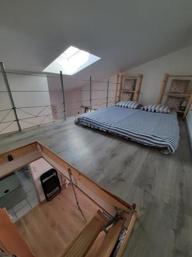 Cette chambre mansardée est dotée de parquet et de 2 lits. dans l'établissement Studio neuf proche Océan, à La Rochelle