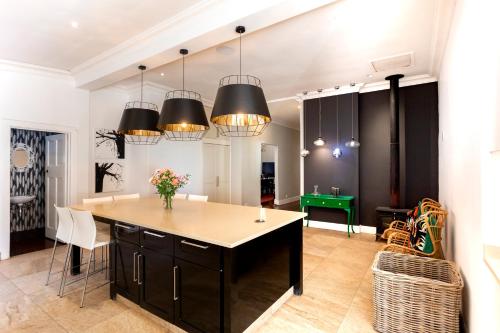 a kitchen with black cabinets and a green table at Taunton Manor in Pietermaritzburg