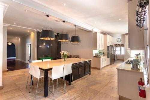 a kitchen with a table and chairs in a room at Taunton Manor in Pietermaritzburg