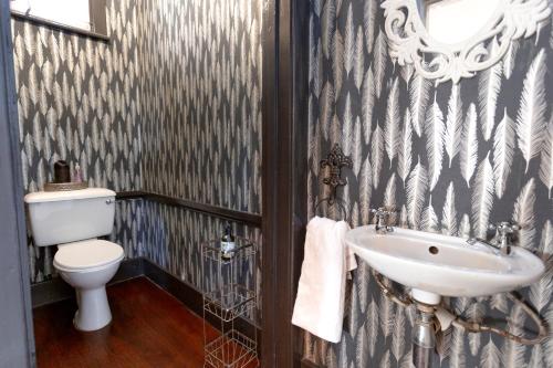 a bathroom with a sink and a toilet at Taunton Manor in Pietermaritzburg