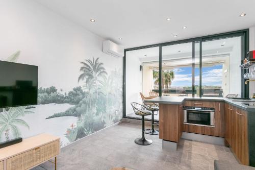 une cuisine avec une grande fresque murale ornée de palmiers. dans l'établissement Luxury House Port Nature naturiste, au Cap d'Agde