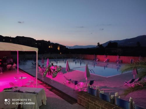 a swimming pool with pink lighting in a resort at Le Rocce in SantʼAgata deʼ Goti