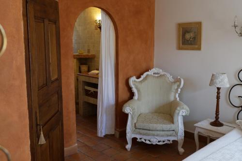 a room with a chair and a mirror in a bedroom at Chambres d'hôtes et studios de charme - A Mandria in Murato