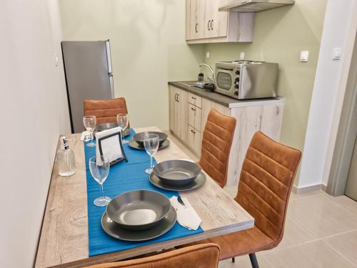 a kitchen with a wooden table with a blue table cloth at Epipleon Luxury Suites - 107 - Διαμέρισμα 85τμ - Θέα στη θάλασσα in Nafpaktos