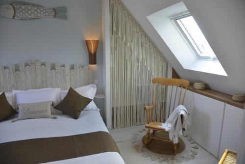 een slaapkamer met een bed, een raam en een stoel bij Céleste In in Port-Louis