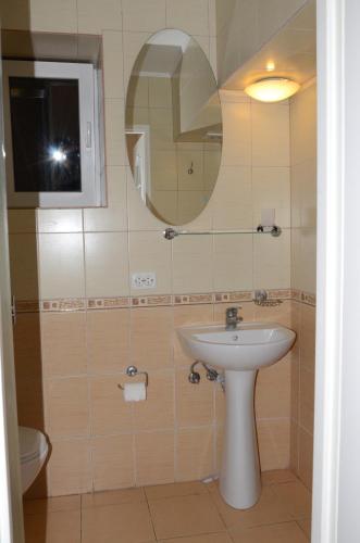 a bathroom with a sink and a mirror and a toilet at Burger Plus Inn in Lviv