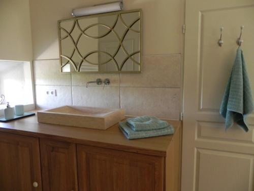 a bathroom with a sink and a mirror on a counter at Les Lavandes in Tulette