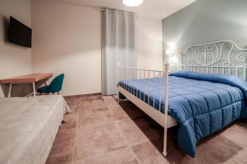 1 dormitorio con cama, mesa y escritorio en La Casa Tra Gli Ulivi, en Asís