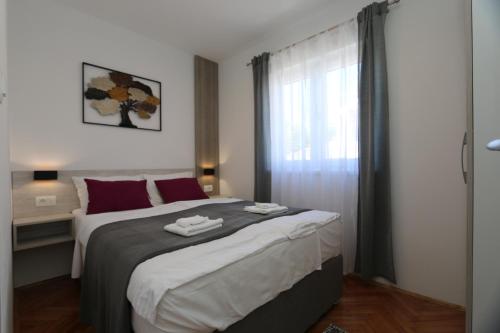 een slaapkamer met een groot bed en een raam bij Apartment SKVICALO in Šilo