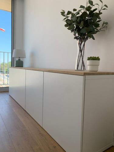 a white kitchen with a counter with a plant on it at Strandcabane in Nieuwpoort
