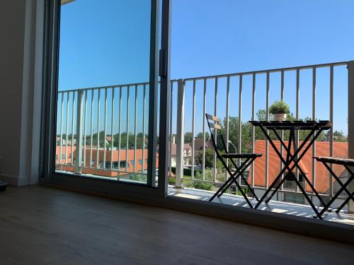 a balcony with a table and a view of a building at Strandcabane in Nieuwpoort
