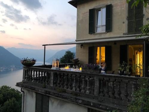 a house with a balcony with a view of the water at B&B Villa le Ortensie in Faggeto Lario 