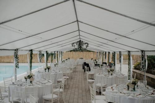 a marquee set up for a wedding with white tables and chairs at Le Rocce in Sant'Agata de' Goti