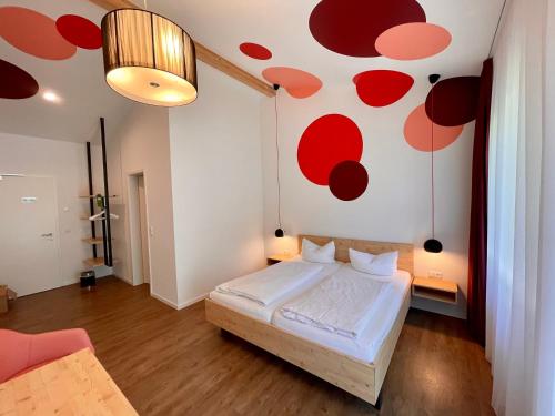 a bedroom with a bed and a wall with red circles at Busses Guesthouse in Freiburg im Breisgau