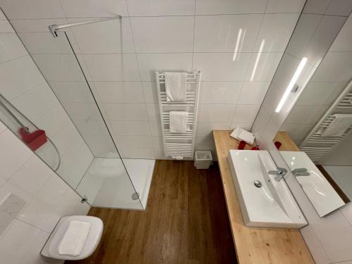 a white bathroom with a sink and a toilet at Busses Guesthouse in Freiburg im Breisgau