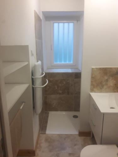 baño con ducha y ventana. en La Maison d Antoine, en Tarascon-sur-Ariège