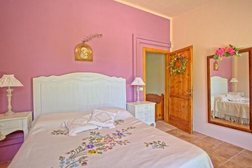 チェルタルドにあるHoliday Home Casa Ovile by PosarelliVillasのピンクの壁のベッドルーム1室(白いベッド1台付)