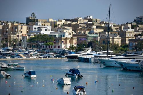 a group of boats in a harbor with buildings at Shore Bridge in Il-Gżira