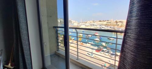 a room with a balcony with a view of a harbor at Shore Bridge in Il-Gżira