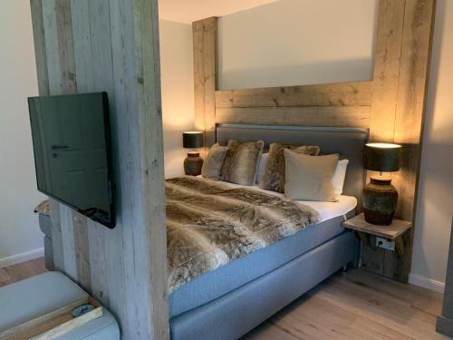 um quarto com uma cama e uma televisão na parede em ferienapartment hahnenklee Apart.3 em Hahnenklee-Bockswiese