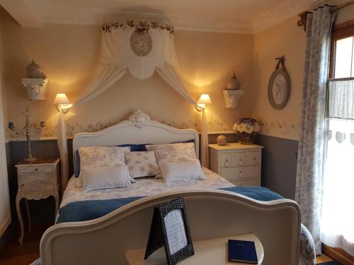 um quarto com uma cama grande e lençóis azuis em La Marlottine em Bourron-Marlotte