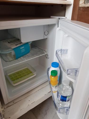- un réfrigérateur ouvert avec des bouteilles d'eau et de nourriture dans l'établissement La Marlottine, à Bourron-Marlotte