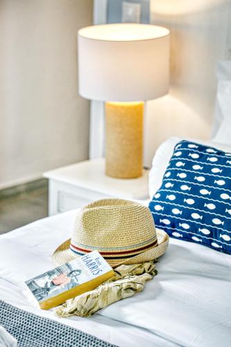a straw hat and a book sitting on a bed at Villa Nautilus in Áfra