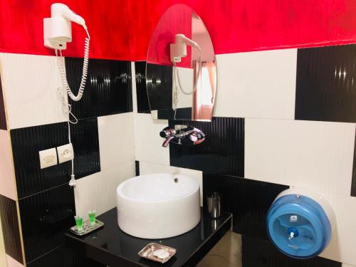 a bathroom with a sink and a phone at Petite Flower Guest House in Talata-maty