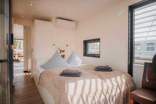 a bedroom with a large bed with two towels on it at Schwimmendes Ferienhaus "Trinity" Ihr Seahome auf der Ostsee in Peenemünde