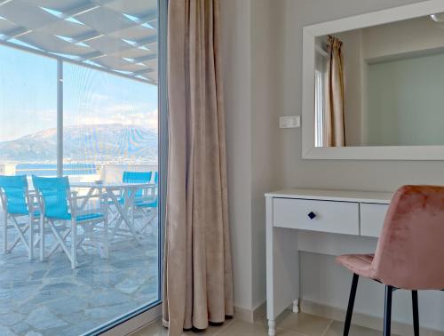 een kamer met een tafel en stoelen en een raam bij Epipleon Luxury Suites -106- Δωμάτιο 40τμ με βεράντα 45τμ μπροστά στην θάλασσα in Nafpaktos