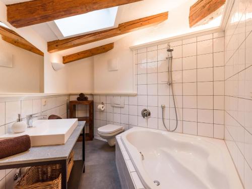 a bathroom with a tub and a toilet and a sink at Ferienwohnungen Egger in Hopfgarten im Brixental