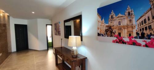 a lamp on a table in a room with two paintings on the wall at Shore Bridge in Il-Gżira