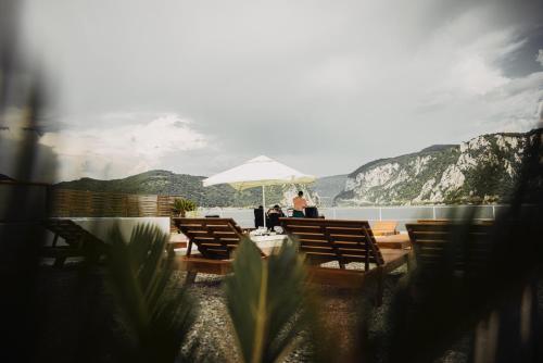 a couple sitting under an umbrella at a table at Vila La Faleza Dubova in Dubova