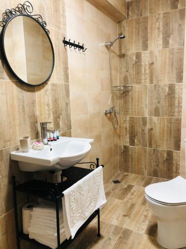a bathroom with a sink and a toilet and a mirror at Colors Boutique in Obzor