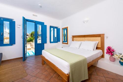 a bedroom with a bed and blue doors at Seaside Breeze in Kamari