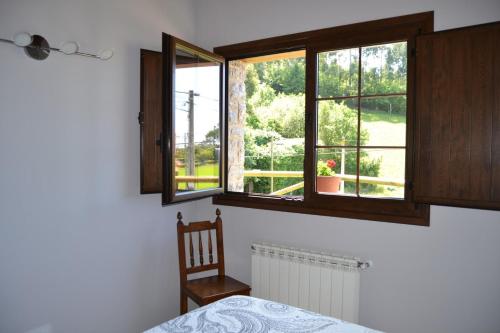 - une chambre avec un lit, une fenêtre et une chaise dans l'établissement Ruiloba II, à Ribadesella