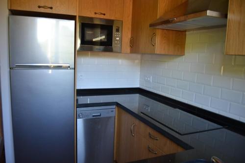 a kitchen with a refrigerator and a microwave at Ruiloba II in Ribadesella