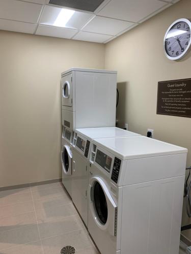 a washer and dryer in a room with a clock at Comfort Inn & Suites in City in the Village of Clarkson