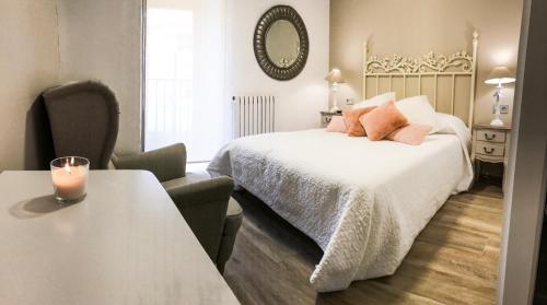a bedroom with a bed and a table with a candle on it at La Casona de Alútiz & Bodega in Samaniego