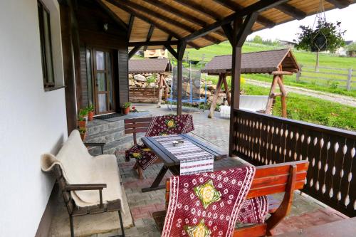 un patio con mesa, sillas y cenador en Casa din Plai - Bucovina en Moldova Suliţa