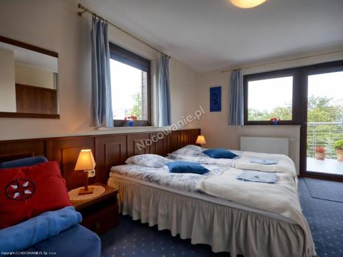dwa łóżka w pokoju z dwoma oknami w obiekcie Willa Anna w mieście Gdynia