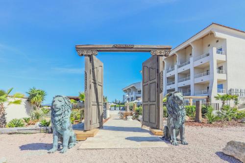 a statue of two lions in front of a building at Bella Vista Hôtel, Suites & Maisons in Porticcio